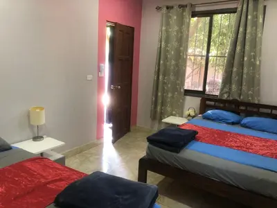 a bedroom with two beds and a window and a door at Tucan in Coco