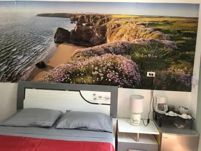 a bedroom with a painting of a beach and flowers at Tucan in Coco