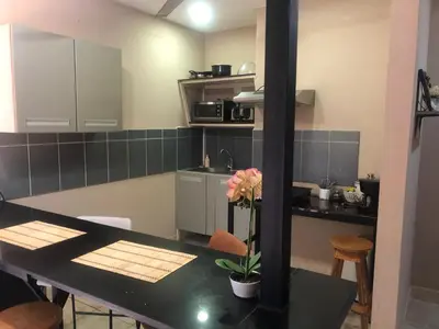 a kitchen with a table with a flower on it at Tucan in Coco