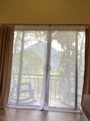 a window in a room with a view of a balcony at Cabaña Rincón Verde - La Fortuna in Fortuna