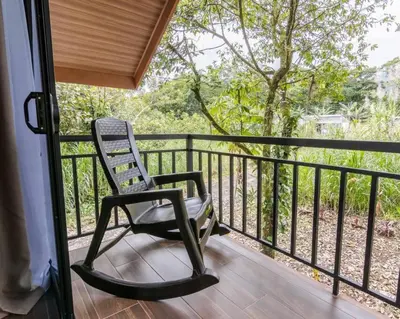 a chair sitting on the porch of a house at Cabaña Rincón Verde - La Fortuna in Fortuna
