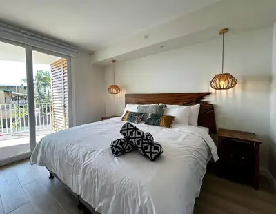 a bedroom with a large bed with two pillows on it at Ocean Front, Luxurious Condo in Downtown Jaco! in Jacó
