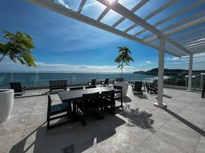 a patio with a table and chairs and the ocean at Ocean Front, Luxurious Condo in Downtown Jaco! in Jacó