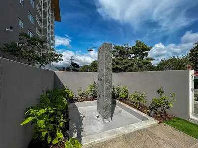 a stone pillar on a wall next to a fence at Ocean Front, Luxurious Condo in Downtown Jaco! in Jacó