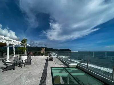 a patio with a view of the ocean and a swimming pool at Ocean Front, Luxurious Condo in Downtown Jaco! in Jacó