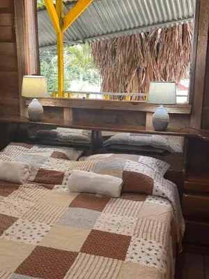a bedroom with two beds and a window at Motel Rio Celeste in Bijagua