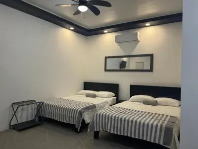 two beds in a room with a ceiling fan at Cameva Villas Your perfect escape in Guatemala