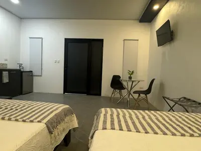 a hotel room with two beds and a table with chairs at Cameva Villas Your perfect escape in Guatemala