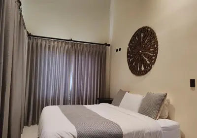 a bedroom with a bed and a clock on the wall at Marenaz Oceanfront Resort in Esterillos Este