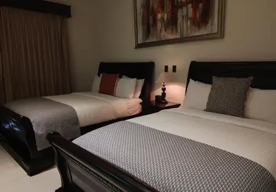 a bedroom with two beds and a lamp in it at Marenaz Oceanfront Resort in Esterillos Este