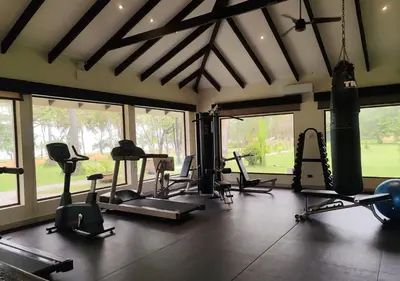 a gym with treadmills and exercise equipment and windows at Marenaz Oceanfront Resort in Esterillos Este