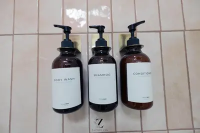 a group of three bottles of soap on a wall at Zapote Zen in San José