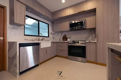 a kitchen with stainless steel appliances and a window at Zapote Zen in San José
