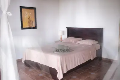 a bedroom with a large bed with a white blanket at Finca Bavaria in Ballena
