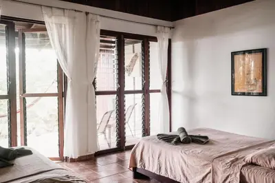 a bedroom with two beds and a large window at Finca Bavaria in Ballena