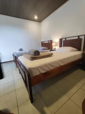 two beds in a room with towels on them at Pura Vida Rentals in Cabuya