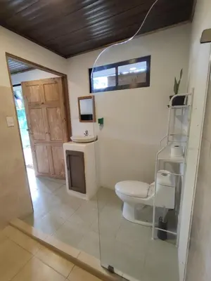 a bathroom with a toilet and a window at Pura Vida Rentals in Cabuya