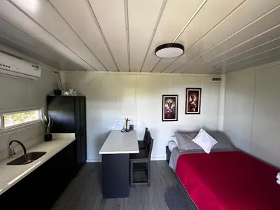 a small room with a bed and a sink and a counter at Dadirri Cozy House Santa Elena Monteverde in Monteverde Costa Rica