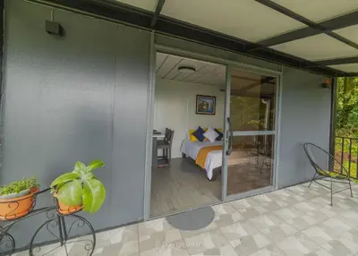 a room with a bedroom and a bed and a patio at Dadirri Cozy House Santa Elena Monteverde in Monteverde Costa Rica