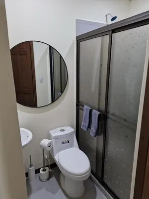 a bathroom with a toilet and a sink and a mirror at Manuel Antonio Tropical Twins in Quepos