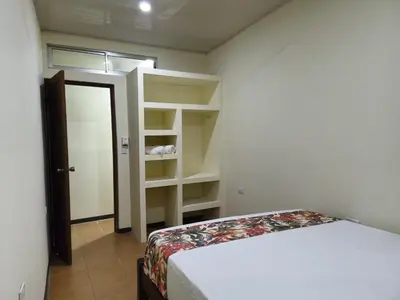 a bedroom with a bed and open shelves at Manuel Antonio Tropical Twins in Quepos