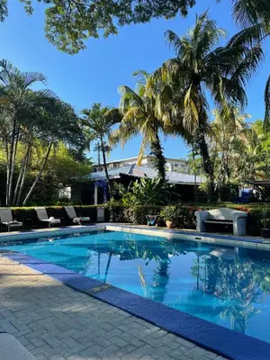 a swimming pool with palm trees in the background at La Puerta del Sol in Coco