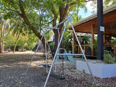 a swing set in a park next to a building at La Puerta del Sol in Coco