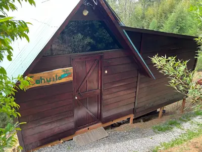 a small wooden hut with a door in it at Vista Hermosa Lodge in Aserrí