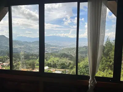 a window with a view of a city at Vista Hermosa Lodge in Aserrí