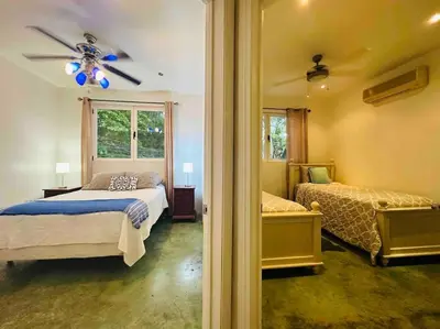 a bedroom with two beds and a ceiling fan at Gorgeous Beachfront Home in Playa Potrero in Playa Flamingo