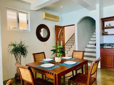 a dining room with a wooden table and chairs at Gorgeous Beachfront Home in Playa Potrero in Playa Flamingo