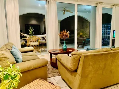 a living room with two couches and a table at Gorgeous Beachfront Home in Playa Potrero in Playa Flamingo