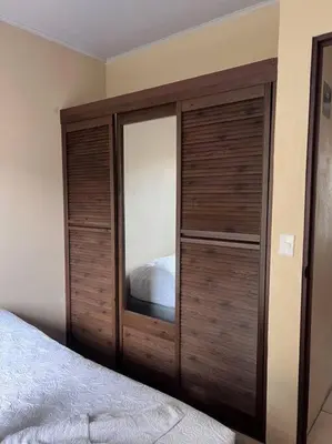 a bedroom with a large wooden cabinet next to a bed at Apartamentos del Sol #2 in Tilarán