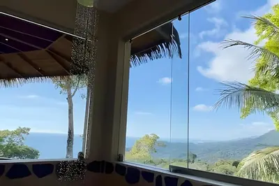 a room with a window with a view of the ocean at MonkeyRanch LuxLodge in Dominicalito