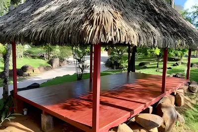 a hut with a thatched roof and a bench at MonkeyRanch LuxLodge in Dominicalito