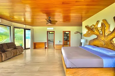 a bedroom with a large bed and a couch at MonkeyRanch LuxLodge in Dominicalito