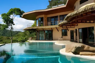 a swimming pool in front of a house at MonkeyRanch LuxLodge in Dominicalito