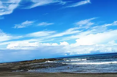 a beach with a blue sky and the ocean at Cabinas Guacamaya in Cabuya