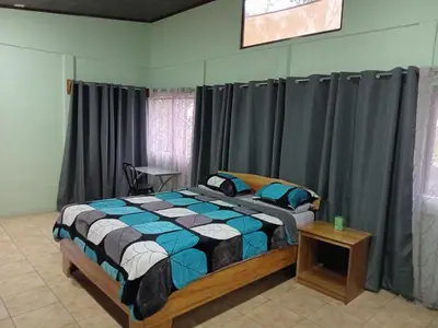 a bedroom with a bed in a room with curtains at Hospedaje Casa Coyote in Hacienda Monteverde