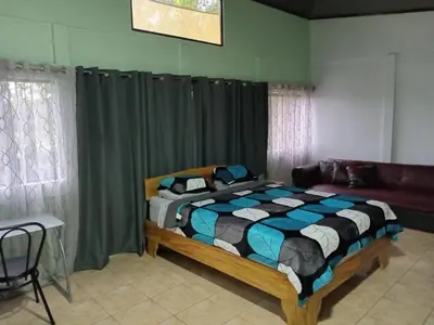 a bedroom with a bed in a room with curtains at Hospedaje Casa Coyote in Hacienda Monteverde