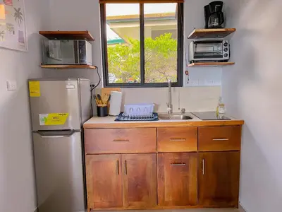 a small kitchen with a refrigerator and a sink at Monstera Apartments Monteverde in Monteverde Costa Rica