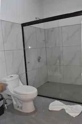 a bathroom with a toilet and a glass shower at Casa Jaspe Monteverde - Balcón vista en Monteverde in Monteverde Costa Rica