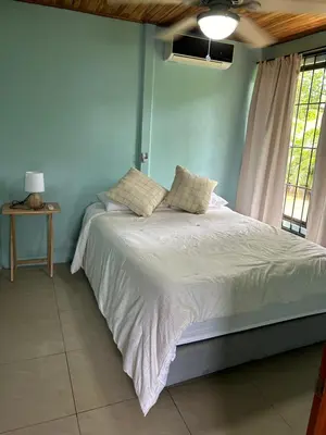 a bedroom with a bed with white sheets and a window at Casa anturio 2 in Fortuna