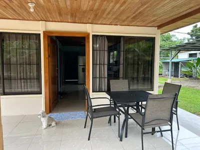 a dog sitting on a patio with a table and chairs at Casa anturio 2 in Fortuna