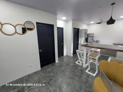 a kitchen with black doors and a counter with stools at DEPARTAMENTOs HABY 1 in Paquera