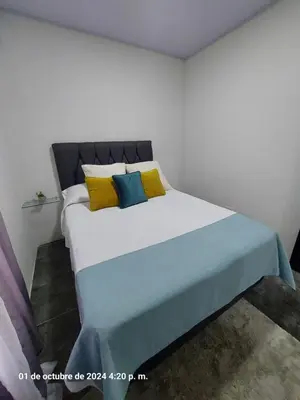 a bedroom with a large bed with yellow and blue pillows at DEPARTAMENTOs HABY 1 in Paquera