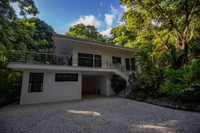 a house with a balcony on top of it at Four Winds Properties A Short Walk to the Beach in Nosara