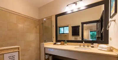 a bathroom with a sink and a large mirror at Four Winds Properties A Short Walk to the Beach in Nosara