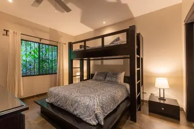 a bedroom with a bunk bed and a window at Four Winds Properties A Short Walk to the Beach in Nosara