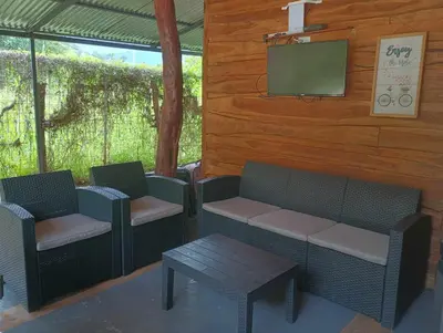 a porch with two chairs and a table and a tv at Blue Zone Cozy Cabaña Peaceful Getaway in Santa María